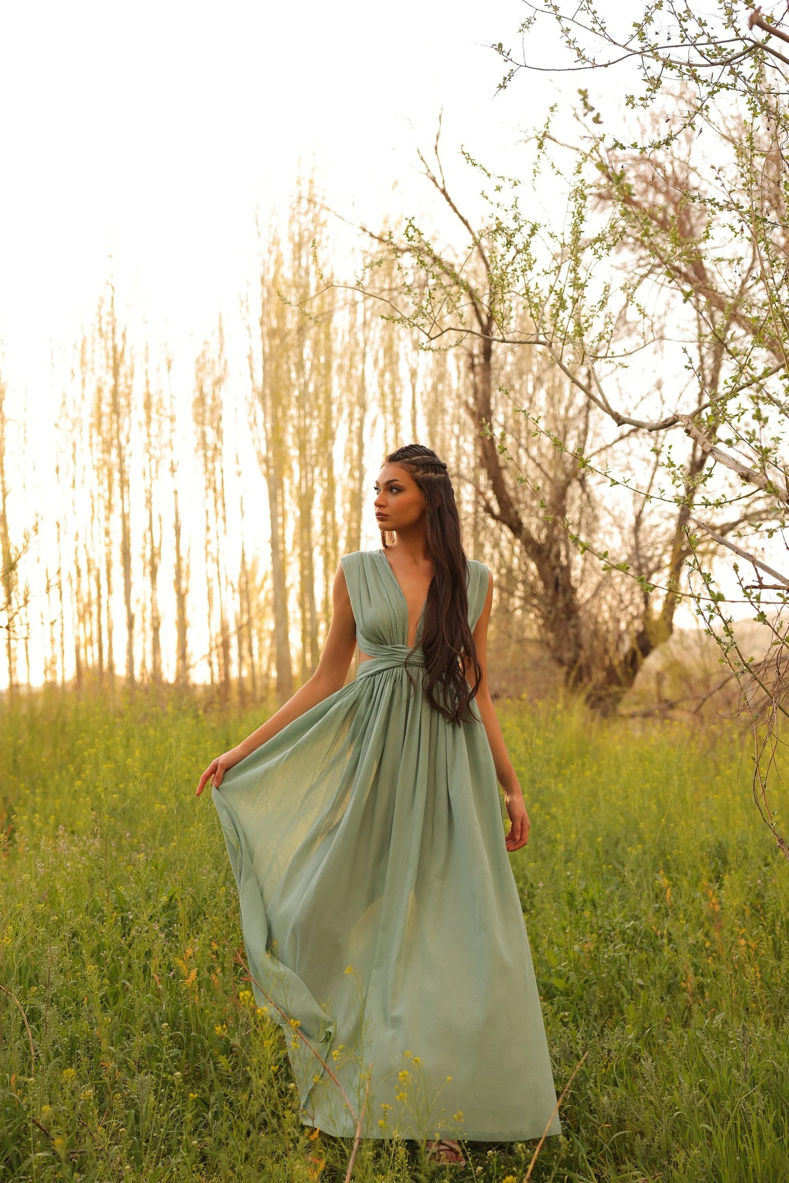Rochie maxi verde-mentă, cu bust drapat și fustă amplă, purtată într-un câmp